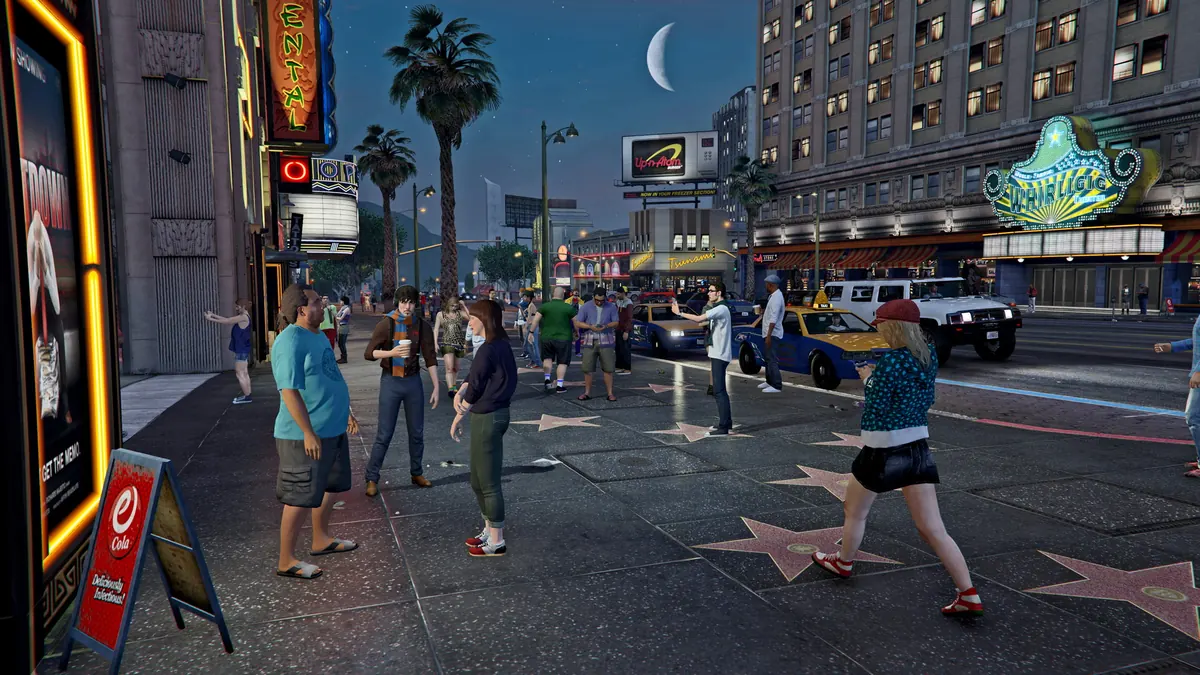 Pedestrians walking along the Vinewood Boulevard walk of fame at night in GTA V