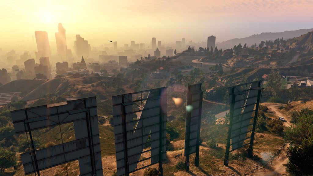 A view over the city from behind the giant white letters of the Vinewood sign at sunset